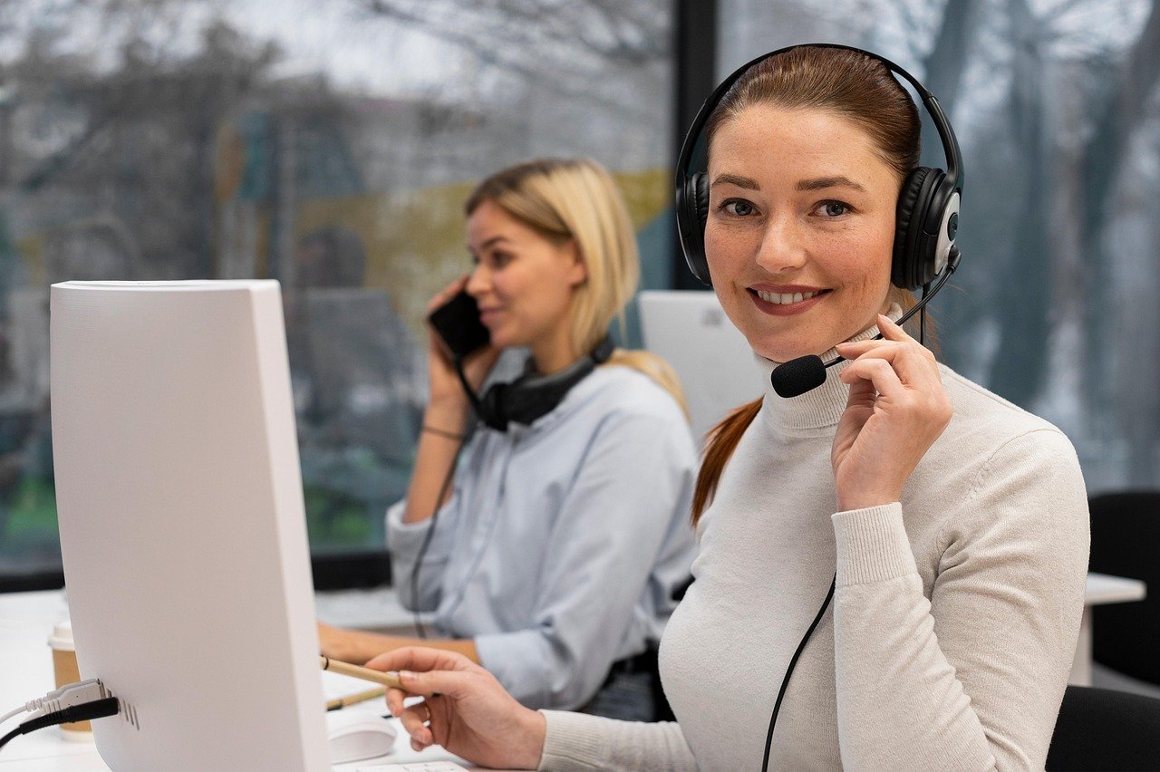A diverse team of customer service representatives wearing headsets and smiling.